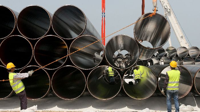 Operai scaricano i tubi appena arrivati per la costruzione del futuro Gasdotto Trans-Adriatico. © Afp 2021/Gent Shkullaku. Da: it.sputniknews.com.