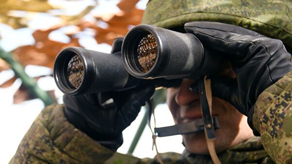 Un militare osserva il territorio con un binocolo. © Sputnik.